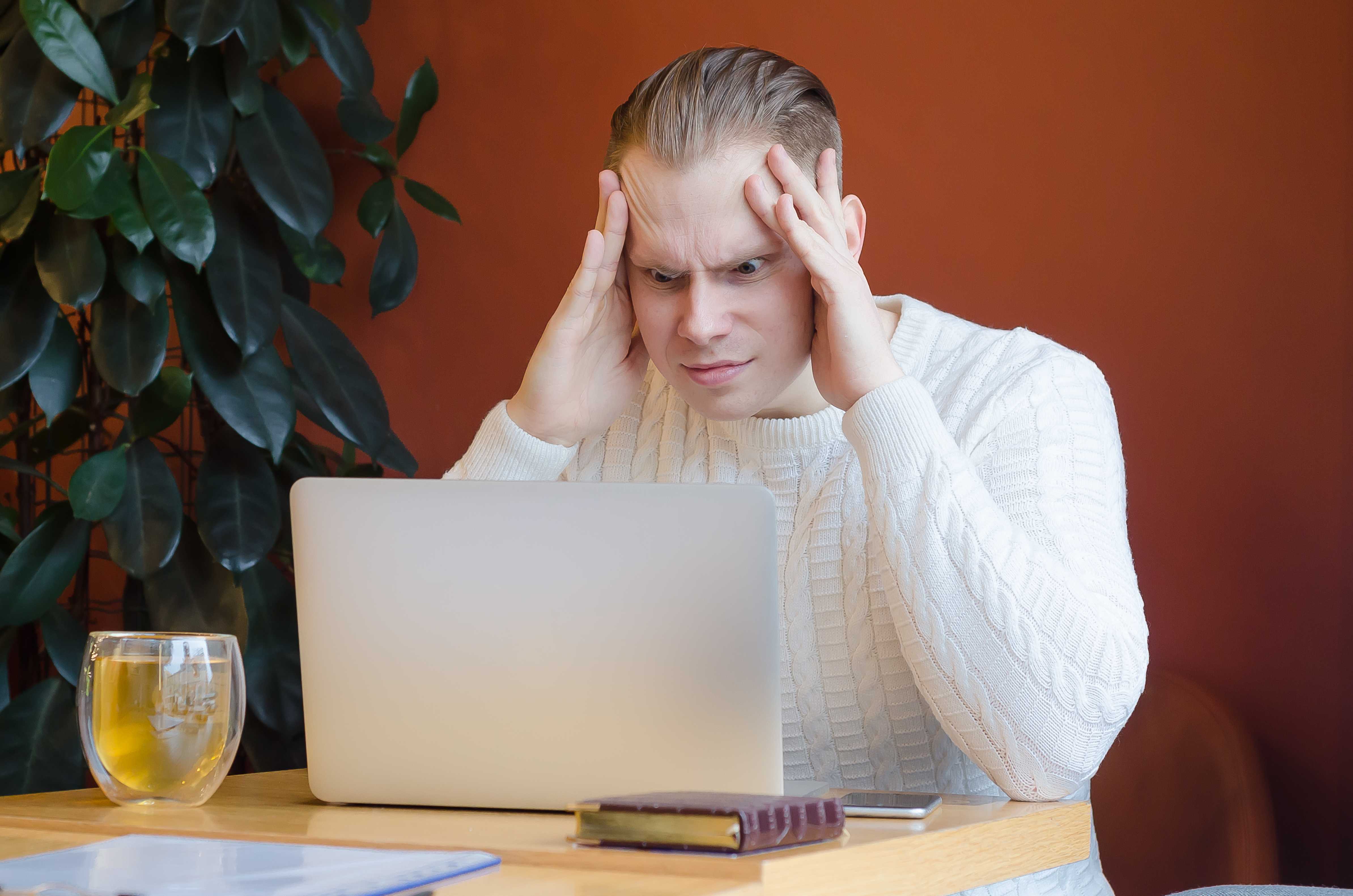 man-looks-in-horror-at-the-laptop-clings-to-his-head-headache-from-computer-screen-human-emotions-depreciation-of-the-currency-businessman-accountant-in-shock-lost-bet man-looks-in-horror-at-the-laptop-clings-to-his-head-headache-from-computer-screen-human-emotions-depreciation-of-the-currency-businessman-accountant-in-shock-lost-bet